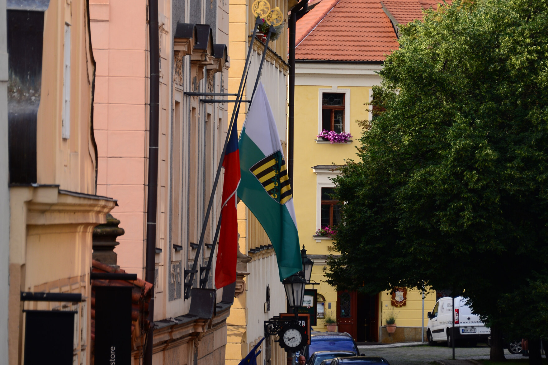 Tschechien- und Sachsen-Fahnen an einem alten Haus, im Hintergrund Altstadt